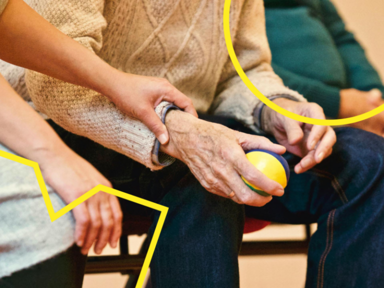 A close up photo of a care worker holding the arm of an individual in their care